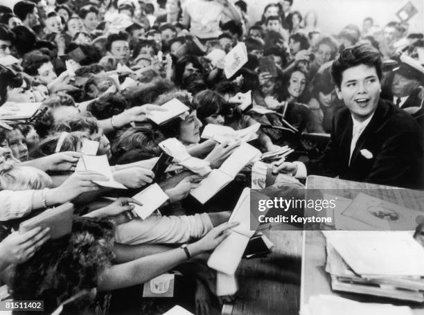 Year-old English pop singer Cliff Richard is mobbed by fans at the Hulton Boys and Girls Exhibition at Olympia's Disc Theatre, 19th August 1959.