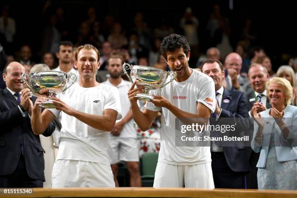 Marcelo Melo of Brazil and Lukasz Kubot of Poland celebrate victory with their trophies after the Gentlemen's Doubles final against Oliver Marach of...