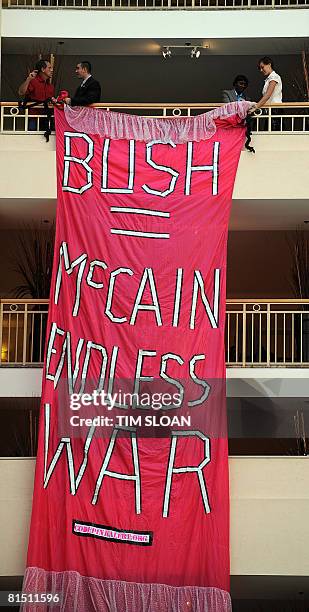 Security guards remove a Code Pink banner as US Republican presidential candidate US Sen. John McCain speaks during the 2008 National Small Business...