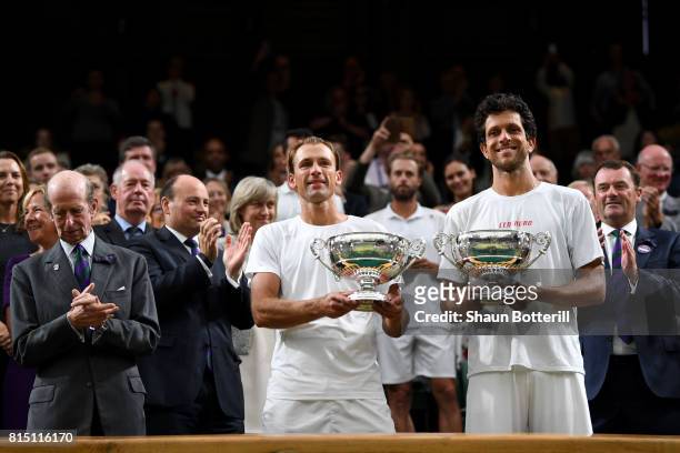 Marcelo Melo of Brazil and Lukasz Kubot of Poland celebrate victory with their trophies after the Gentlemen's Doubles final against Oliver Marach of...