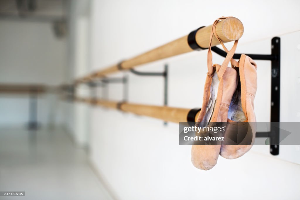https://media.gettyimages.com/id/815130736/photo/ballet-shoes-hanging-on-wooden-barre-in-studio.jpg?s=1024x1024&w=gi&k=20&c=zbQo8e8uSuWfiWK0aPEi4oytzl4XGBiUQRi5LaAfwn0=