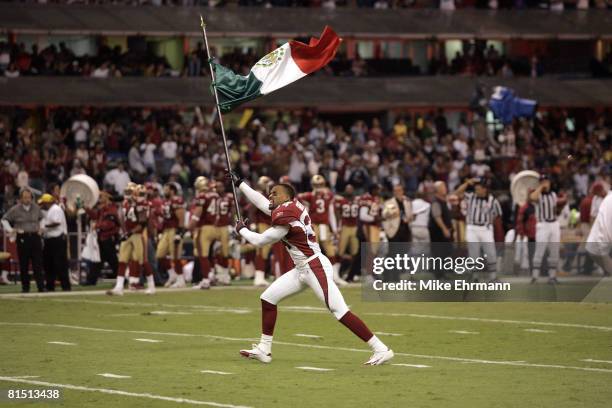 Robert Griffith of the Arizona Cardinals carries out the Mexican flag before a game against the San Francisco 49ers at Estadio Azteca in Mexico City,...