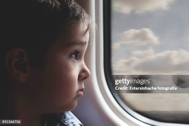niño observando desde la ventanilla de un tren - un solo niño stock pictures, royalty-free photos & images