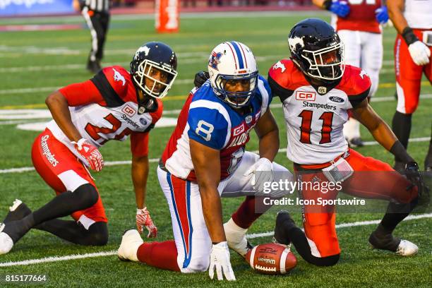 Montreal Alouettes slotback Nik Lewis on the ground with Calgary Stampeders defensive back Joshua Bell after catching a pass during the Calgary...