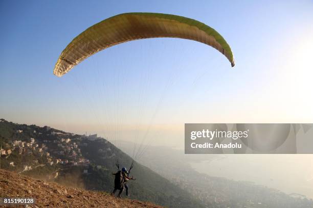 Tandem paragliders start their flight from a mountain in Jounieh district of Beirut, Lebanon on July 15, 2017.