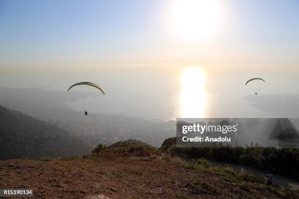 Tandem paragliders start their flight from a mountain in Jounieh district of Beirut, Lebanon on July 15, 2017.