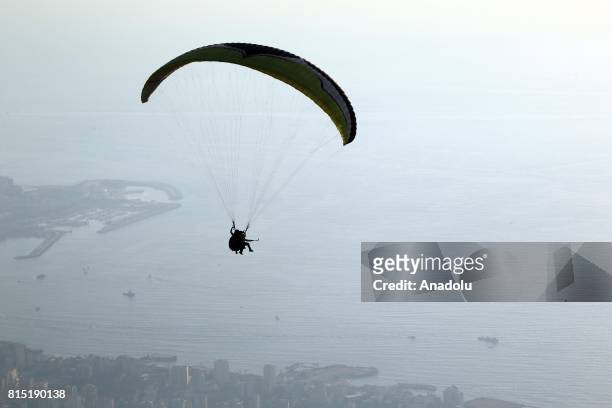 Tandem paragliders start their flight from a mountain in Jounieh district of Beirut, Lebanon on July 15, 2017.