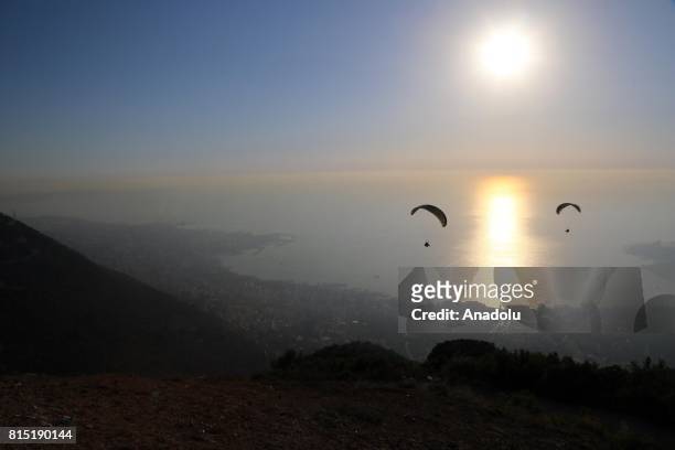 Tandem paragliders start their flight from a mountain in Jounieh district of Beirut, Lebanon on July 15, 2017.