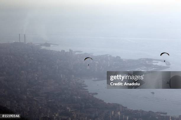 Tandem paragliders start their flight from a mountain in Jounieh district of Beirut, Lebanon on July 15, 2017.