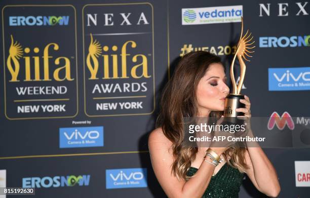 Bollywood singer Kanika Kapoor poses with her trophy on the green carpet at the IIFA Awards July 15, 2017 at the MetLife Stadium in East Rutherford,...
