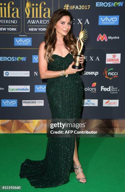 Bollywood singer Kanika Kapoor poses with her trophy on the green carpet at the IIFA Awards July 15, 2017 at the MetLife Stadium in East Rutherford,...