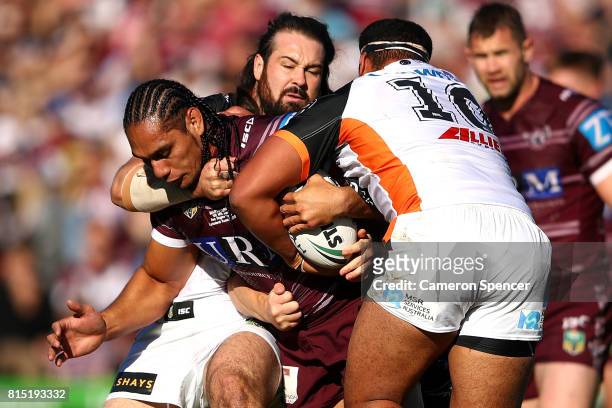 Martin Taupau of the Sea Eagles is tackled during the round 19 NRL match between the Manly Sea Eagles and the Wests Tigers at Lottoland on July 16,...
