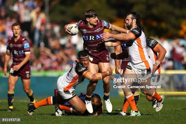 Tom Trbojevic of the Sea Eagles is tackled the round 19 NRL match between the Manly Sea Eagles and the Wests Tigers at Lottoland on July 16, 2017 in...