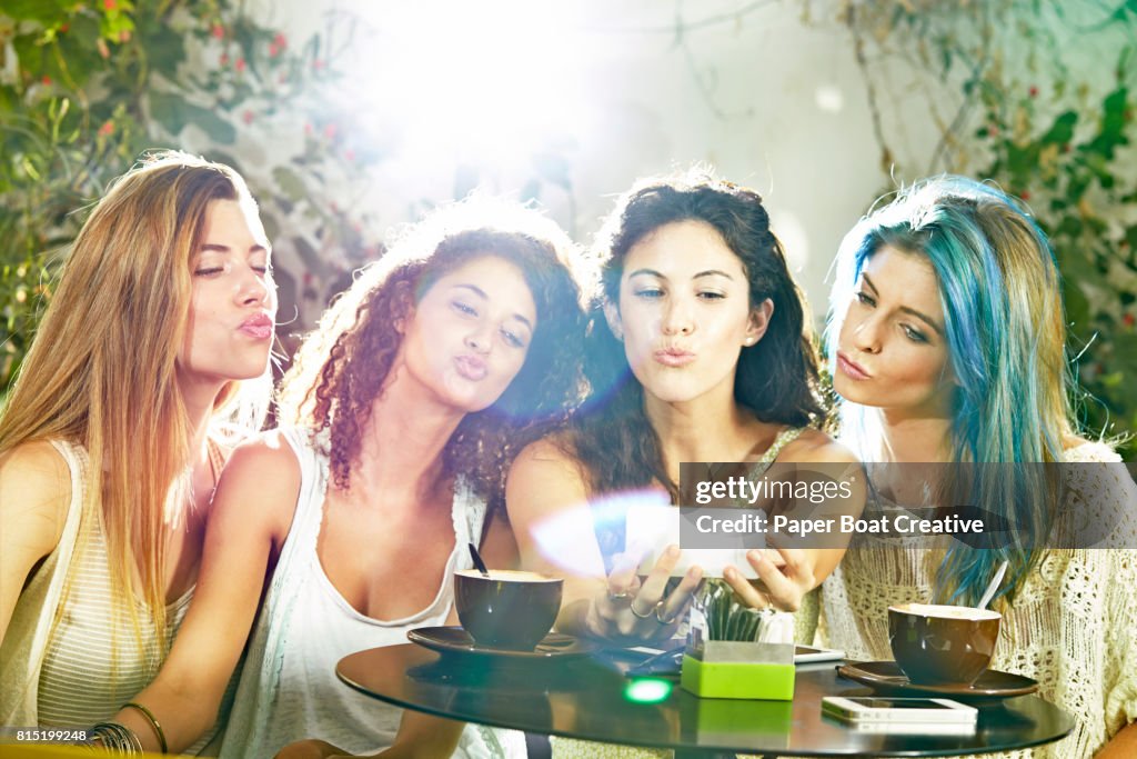 Group of friends at a cafe taking a selfie and pouting with their lips