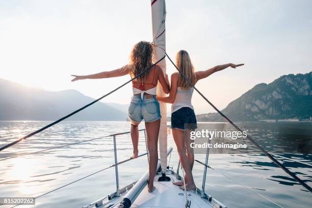 mujeres mirando puesta de sol en la proa de un velero - proa fotografías e imágenes de stock