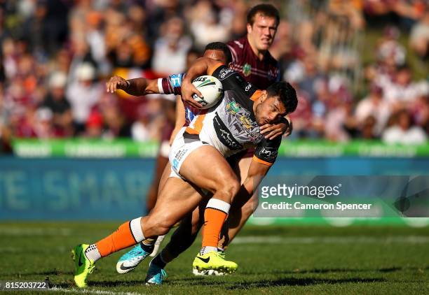 David Nofoaluma of the Tigers is tackled during the round 19 NRL match between the Manly Sea Eagles and the Wests Tigers at Lottoland on July 16,...