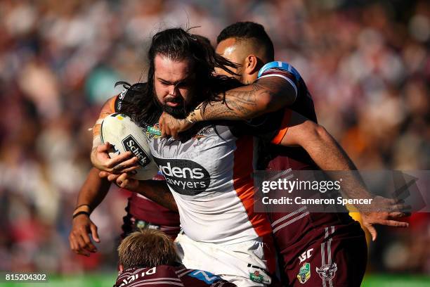 Aaron Woods of the Tigers is tackled during the round 19 NRL match between the Manly Sea Eagles and the Wests Tigers at Lottoland on July 16, 2017 in...