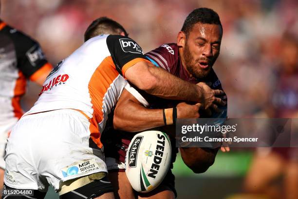 Apisai Koroisau of the Sea Eagles is tackled during the round 19 NRL match between the Manly Sea Eagles and the Wests Tigers at Lottoland on July 16,...