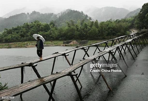 Villager walks on a wooden trestle at the Longchuan Village on June 9, 2008 in Jixi County of Anhui Province, China. The Longchuan Village has been...