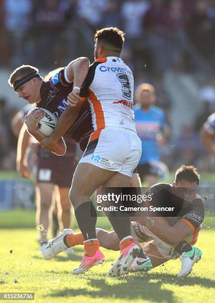 Thomas Trbojevic of the Sea Eagles is tackled during the round 19 NRL match between the Manly Sea Eagles and the Wests Tigers at Lottoland on July...