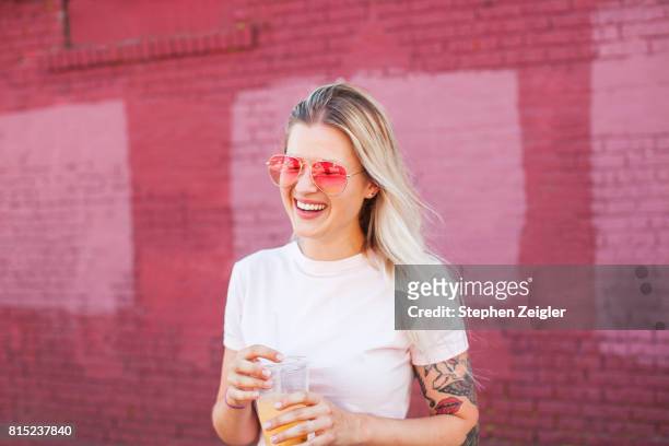 young woman drinking juice - capelli biondi foto e immagini stock