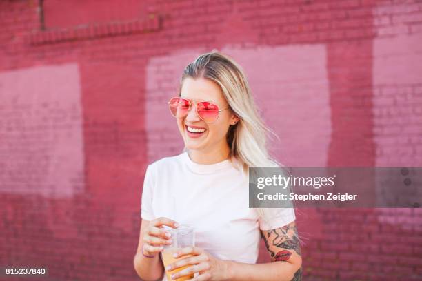 young woman drinking juice - pink shirt stock pictures, royalty-free photos & images