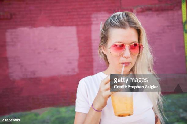 young woman drinking juice - smoothie stock-fotos und bilder