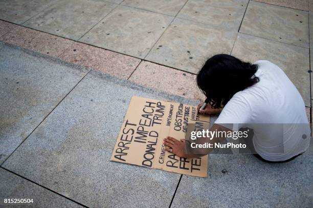 Protestor treats a sign during the Refuse Racism Rally in Philadelphia, Pennsylvania, on July 15, 2017.