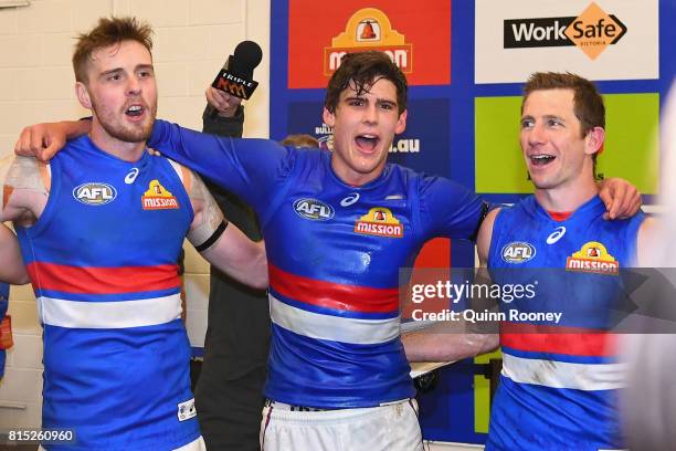 Jordan Roughead, Lewis Young and Dale Morris of the Bulldogs sing the song in the rooms after winning the round 17 AFL match between the Carlton...