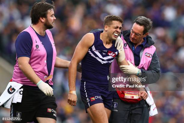 Stephen Hill of the Dockers is assisted from the field after dislocating his shoulder during the round 17 AFL match between the Fremantle Dockers and...