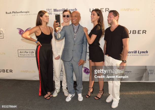 Russell Simmons poses for a selfie with guests during "Midnight At The Oasis" Annual Art For Life Benefit hosted by Russell Simmons' Rush...