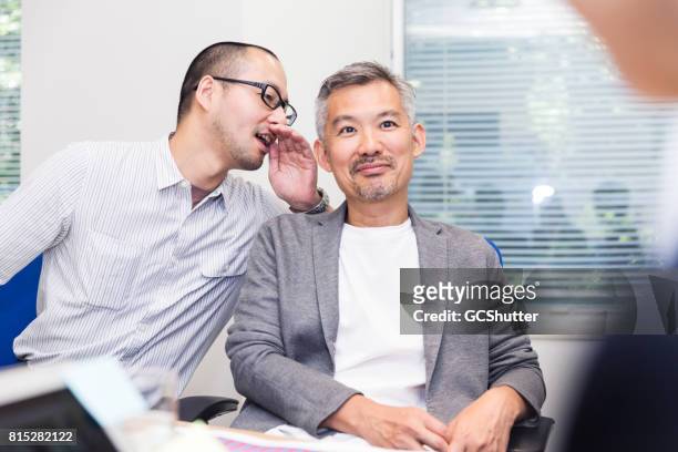 chairman receiving some advice from his colleague - gossip stock pictures, royalty-free photos & images
