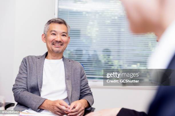 lachende senior business executive - voorzitter stockfoto's en -beelden