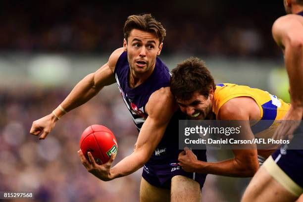 Lachie Weller of the Dockers handpasses the ball under pressure from Andrew Gaff of the Eagles during the 2017 AFL round 17 match between the...