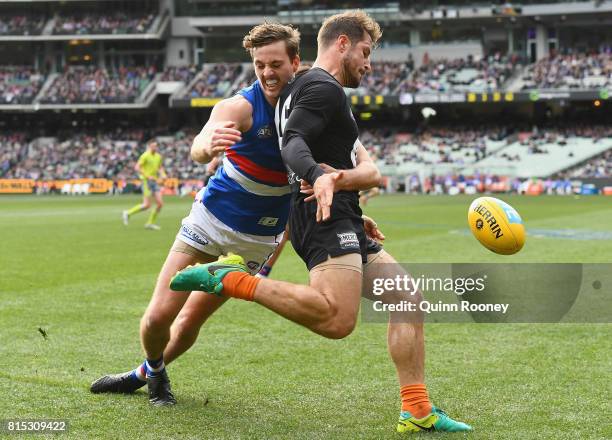 Zaine Cordy of the Bulldogs tackles Matthew Wright of the Blues as he kicks during the round 17 AFL match between the Carlton Blues and the Western...