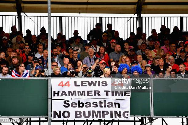 Lewis Hamilton of Great Britain and Mercedes GP fans with a sign referencing the incident between Sebastian Vettel of Germany and Ferrari and Lewis...