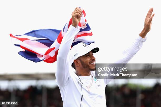 Lewis Hamilton of Great Britain and Mercedes GP waves to the crowd on the drivers parade before the Formula One Grand Prix of Great Britain at...