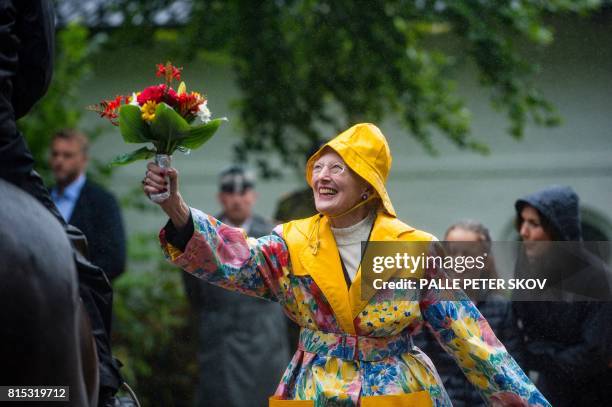 Denmark's Queen Margrethe accepts flowers from the parade at Graasten castle on July 16, 2017. / Denmark OUT