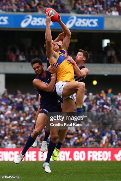 Drew Petrie of the Eagles marks the ball against Michael Johnson and Lee Spurr of the Dockers during the round 17 AFL match between the Fremantle...