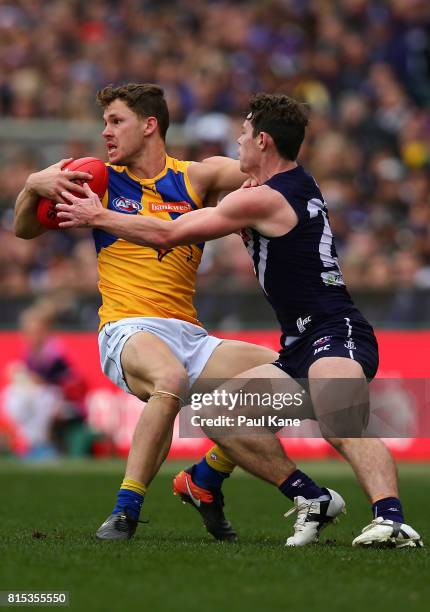 Jack Redden of the Eagles gets tackled by Lachie Neale of the Dockers during the round 17 AFL match between the Fremantle Dockers and the West Coast...