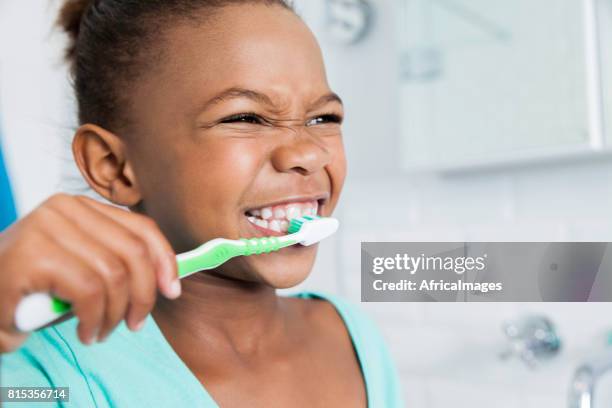 beautiful young girl brushing her teeth. - dental health stock pictures, royalty-free photos & images