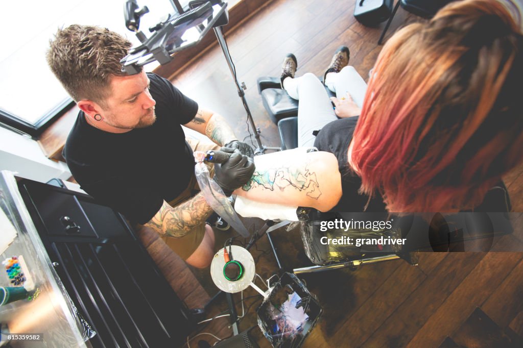 Tattoo Artist Creating New Tattoo on a Young Woman