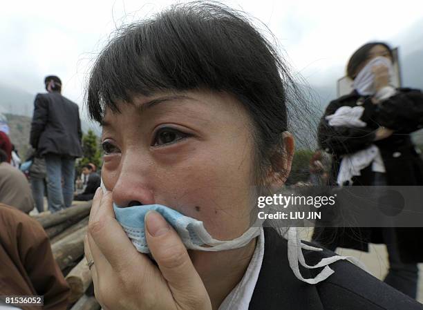 Photo taken on May 15, 2008 shows a woman crying as she watches the rescuers dig the dead bodies from the rubbles of a collapsed elementary school in...