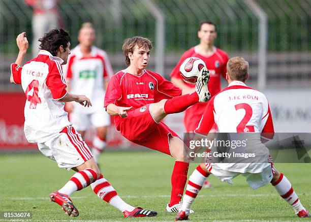 Stephan Salger of Koeln and Robert Wilschrey of Koeln attempt to tackle Gabriel Gallus of Freiburg during the A Juniors semi final match between SC...