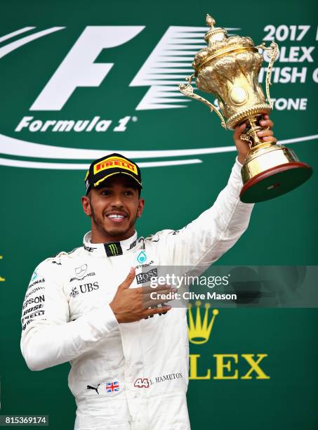 Race winner Lewis Hamilton of Great Britain and Mercedes GP celebrates on the podium during the Formula One Grand Prix of Great Britain at...