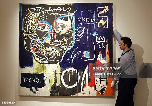 Sotheby's assistant stands holding Untitled by Jean -Michel Basquiat, which is due to be sold on behalf of members of the band U2 on June 12, 2008 in...