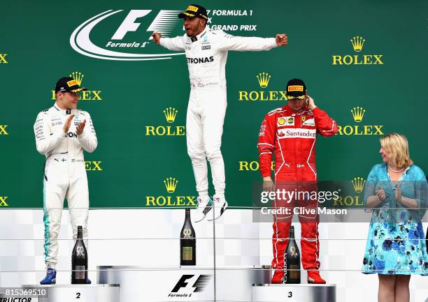 Race winner Lewis Hamilton of Great Britain and Mercedes GP celebrates on the podium with second placed Valtteri Bottas of Finland and Mercedes GP...