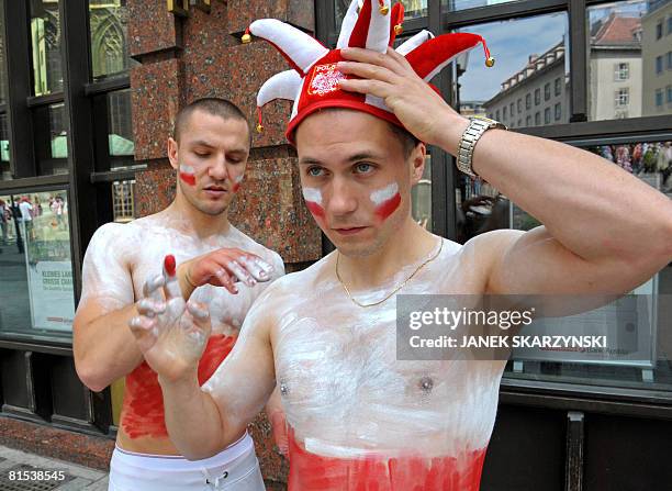 Polish supporters paint themselves with their national colours in front of the Saint Stephans cathedral in central Vienna on June12, 2008 a few hours...