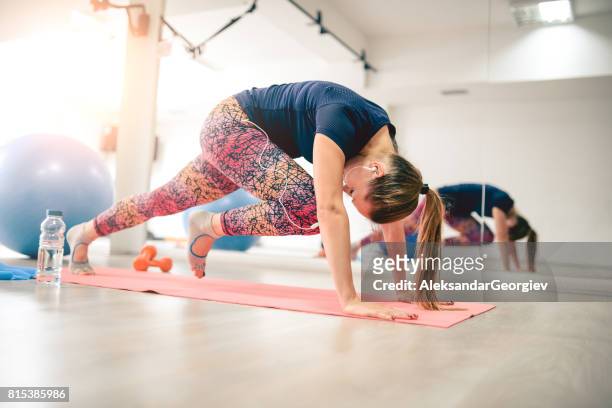 junge weibliche athlet in plank haltung tun laufen abs - gym frau stock-fotos und bilder