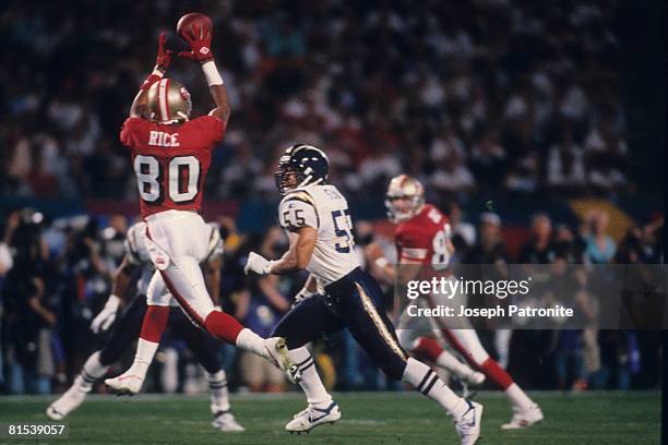 Wide receiver Jerry Rice of the San Francisco 49ers catches a pass behind linebacker Junior Seau of the San Diego Chargers in Super Bowl XXIX at Joe...